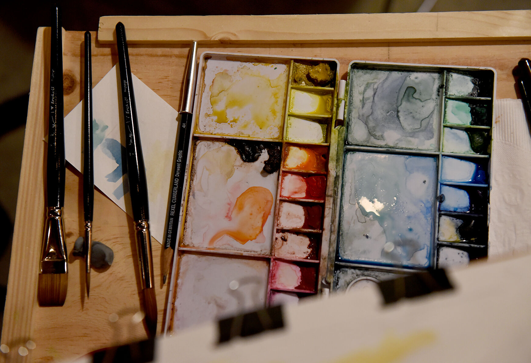 A paint palette and brushes lie on the table